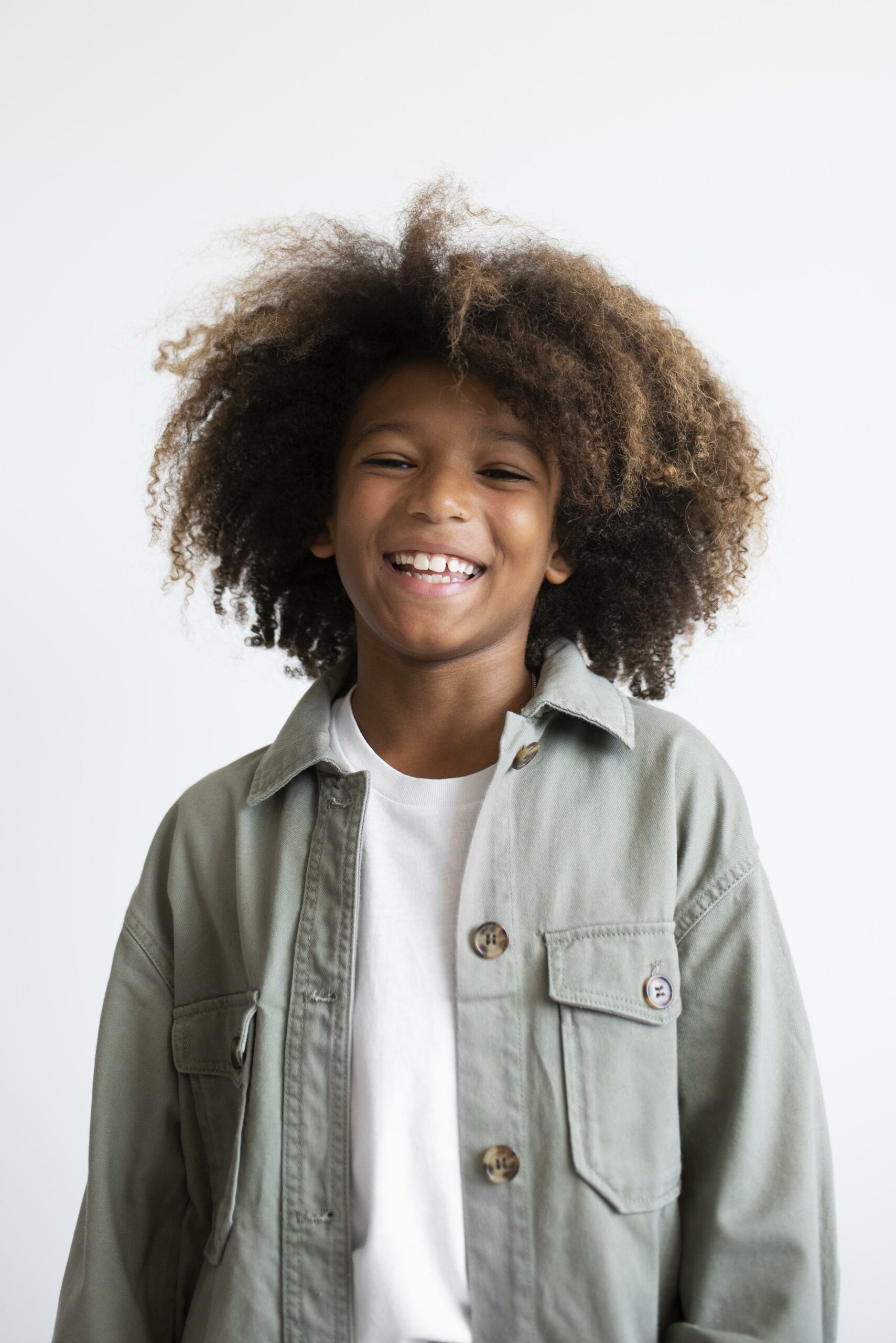 Enfant au cheveux afro souriant à la caméra